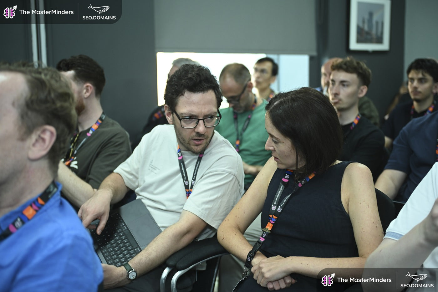 Attendees sharing ideas around a laptop at a previous workshop.